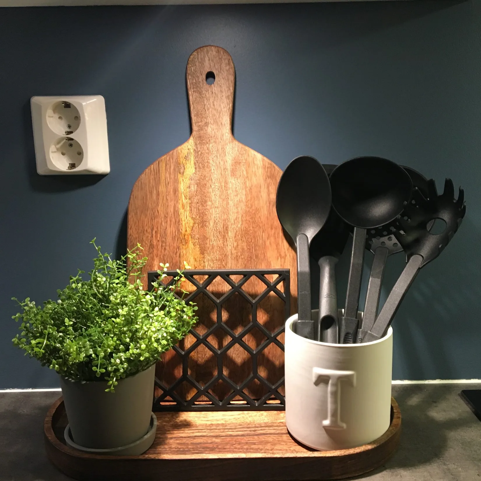 Detalj med mørkeblå vegg, treskjærefjøl og planter fra et interiørprosjekt på Lade i Trondheim